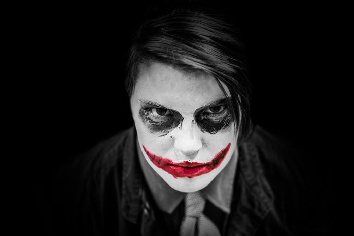 A black and white image of a boy dressed up as the Joker.