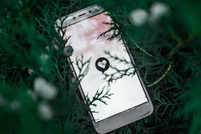 white phone with heart shown in the grass