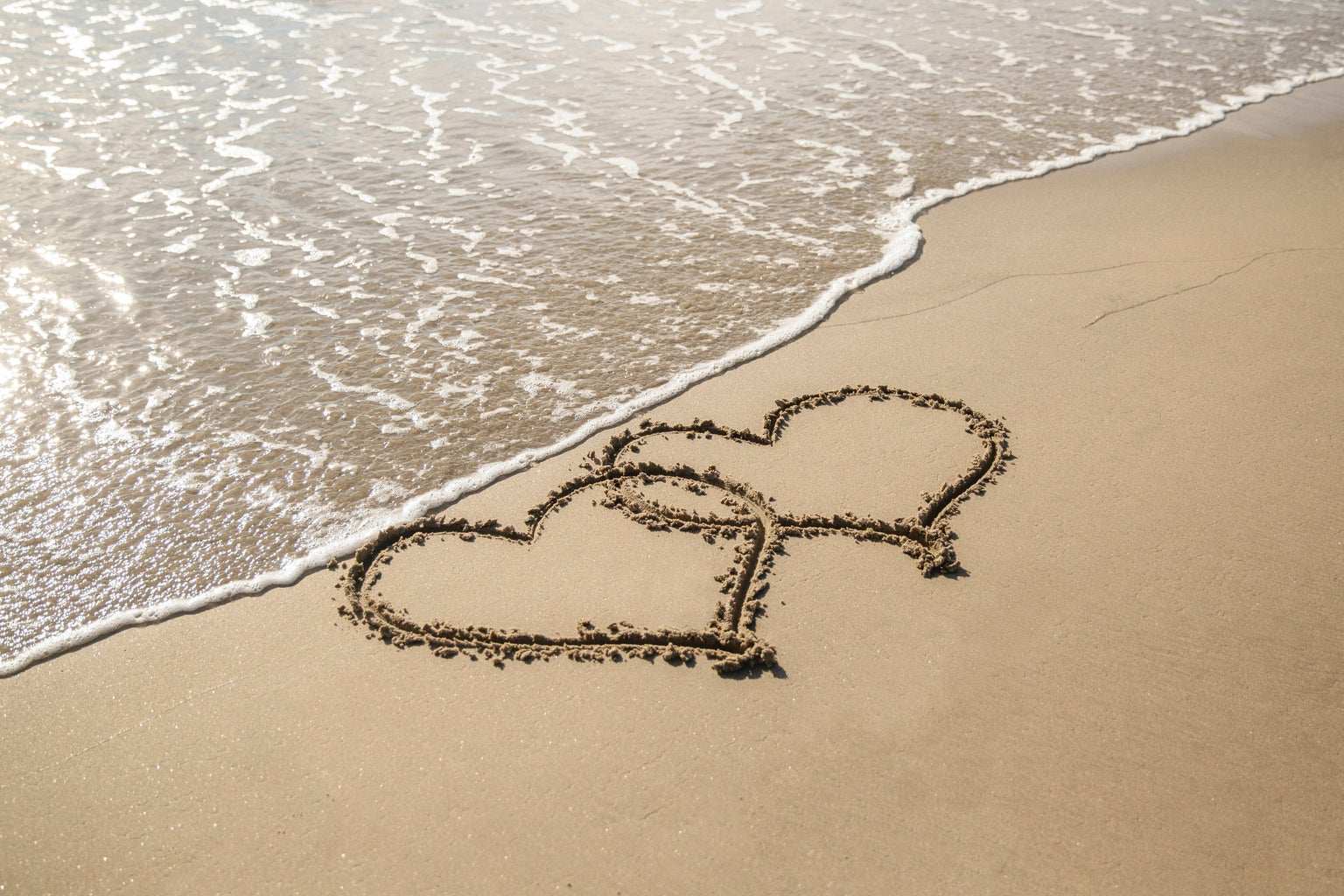 two hearts in sand on a beach