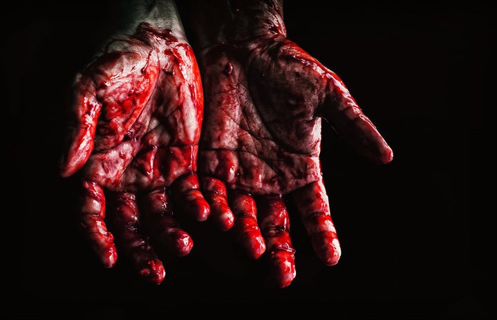 A woman\'s hands palm-up covered in \"blood\"