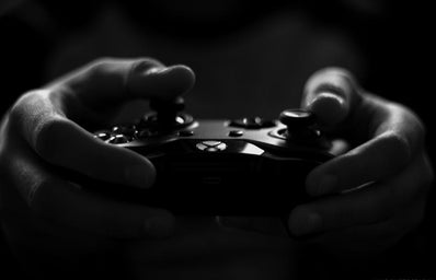 Black and white photo of hands holding an X-box controller