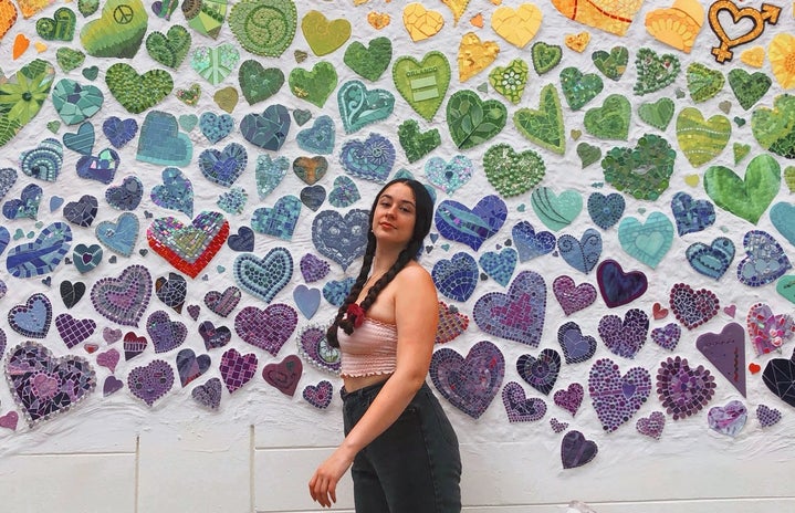 a picture of me in front of a wall of rainbow hearts