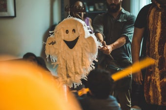 A Halloween Party, someone is hitting a ghost pinata.