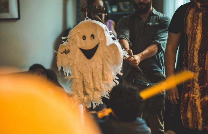 A Halloween Party, someone is hitting a ghost pinata.