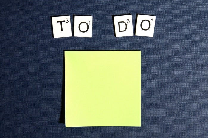 Scrabble tiles spell out "To Do" on a blue background above a yellow sticky note
