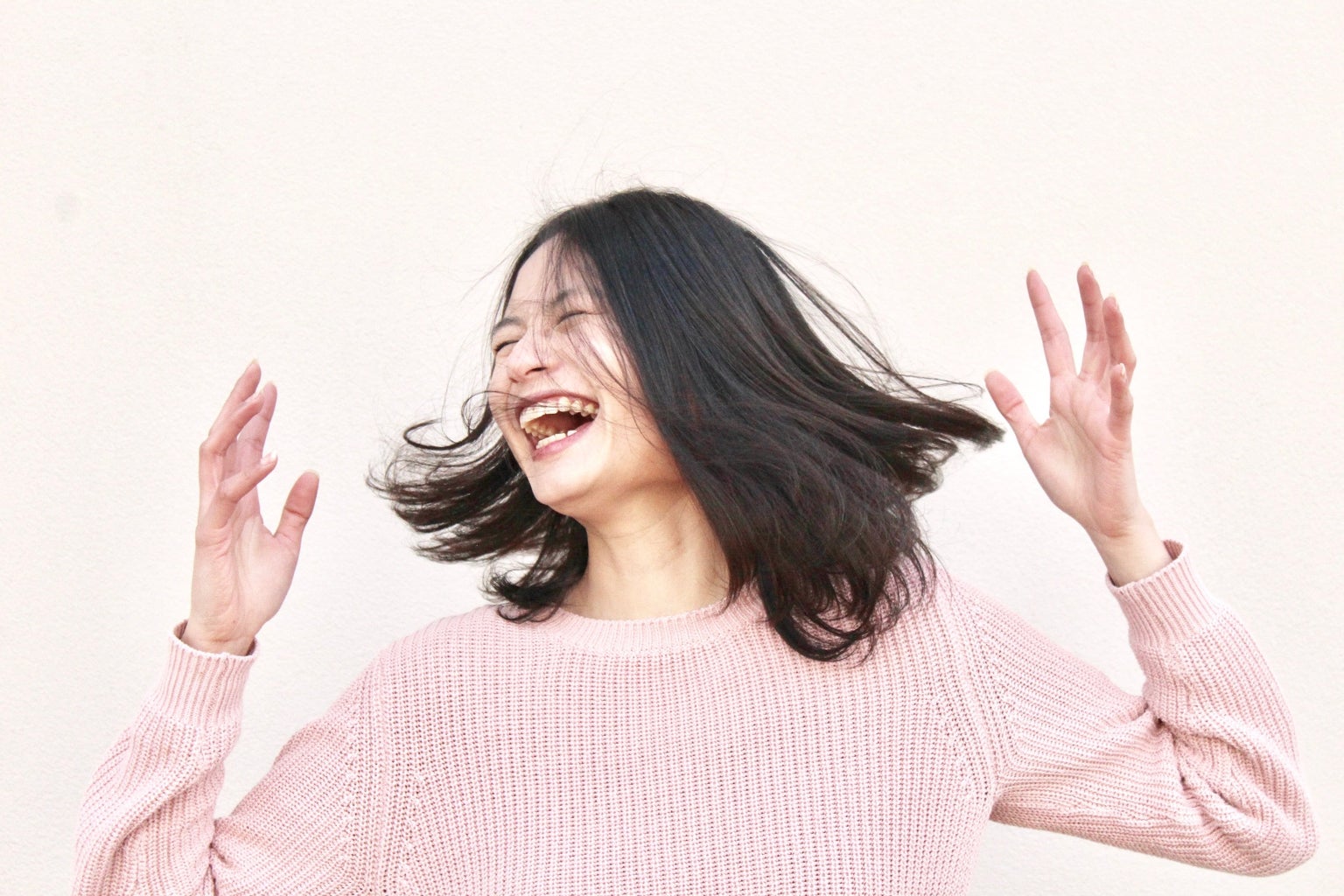 smiling woman in pink sweater