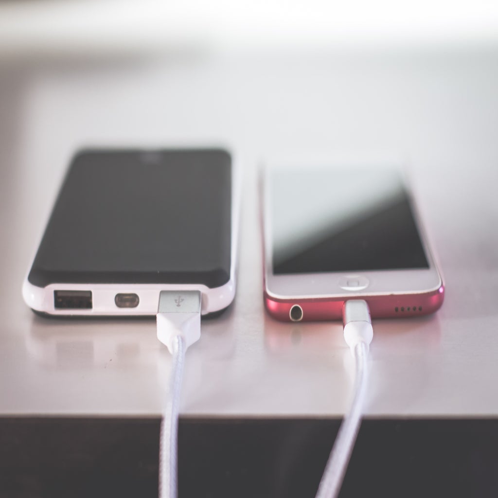 two phones lying flat and plugged in