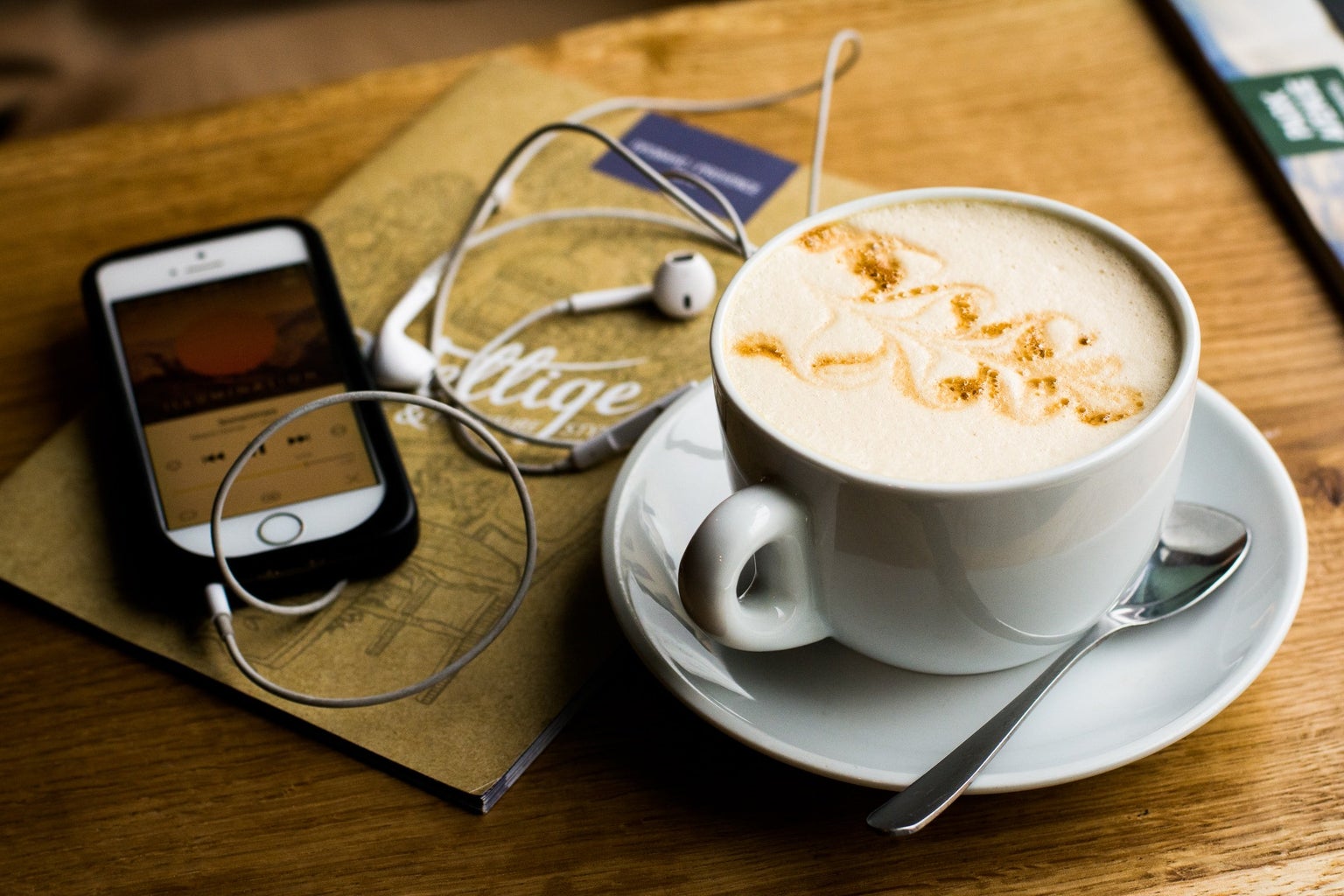 phone, headphones, and coffee with foam art