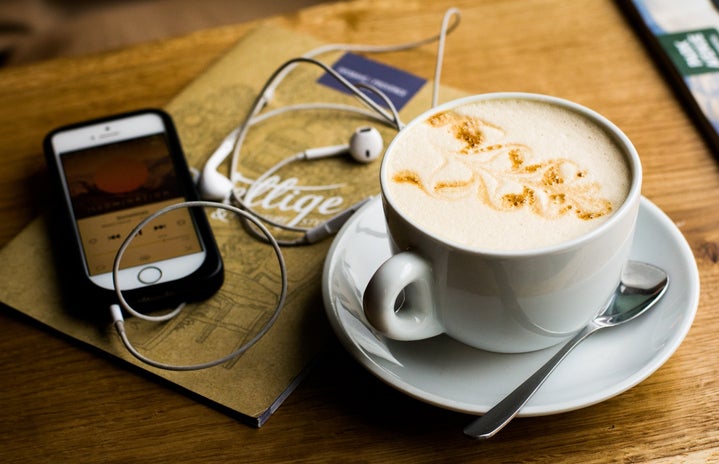 phone, headphones, and coffee with foam art