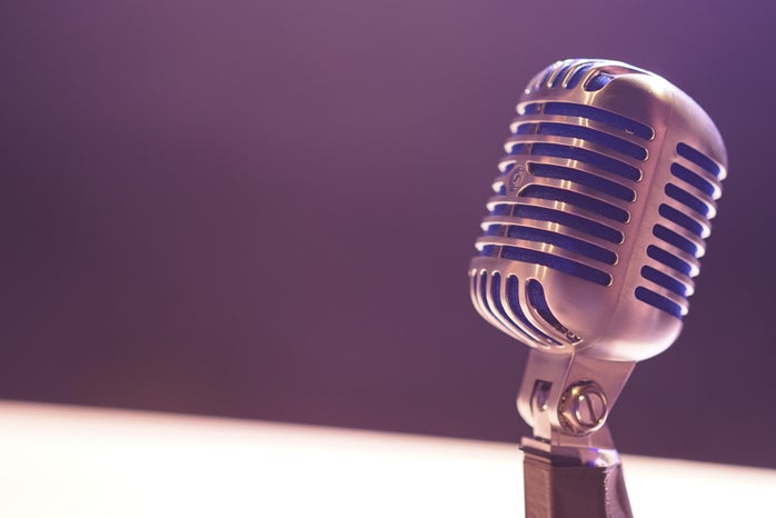 old fashioned crome microphone in front of a purple background