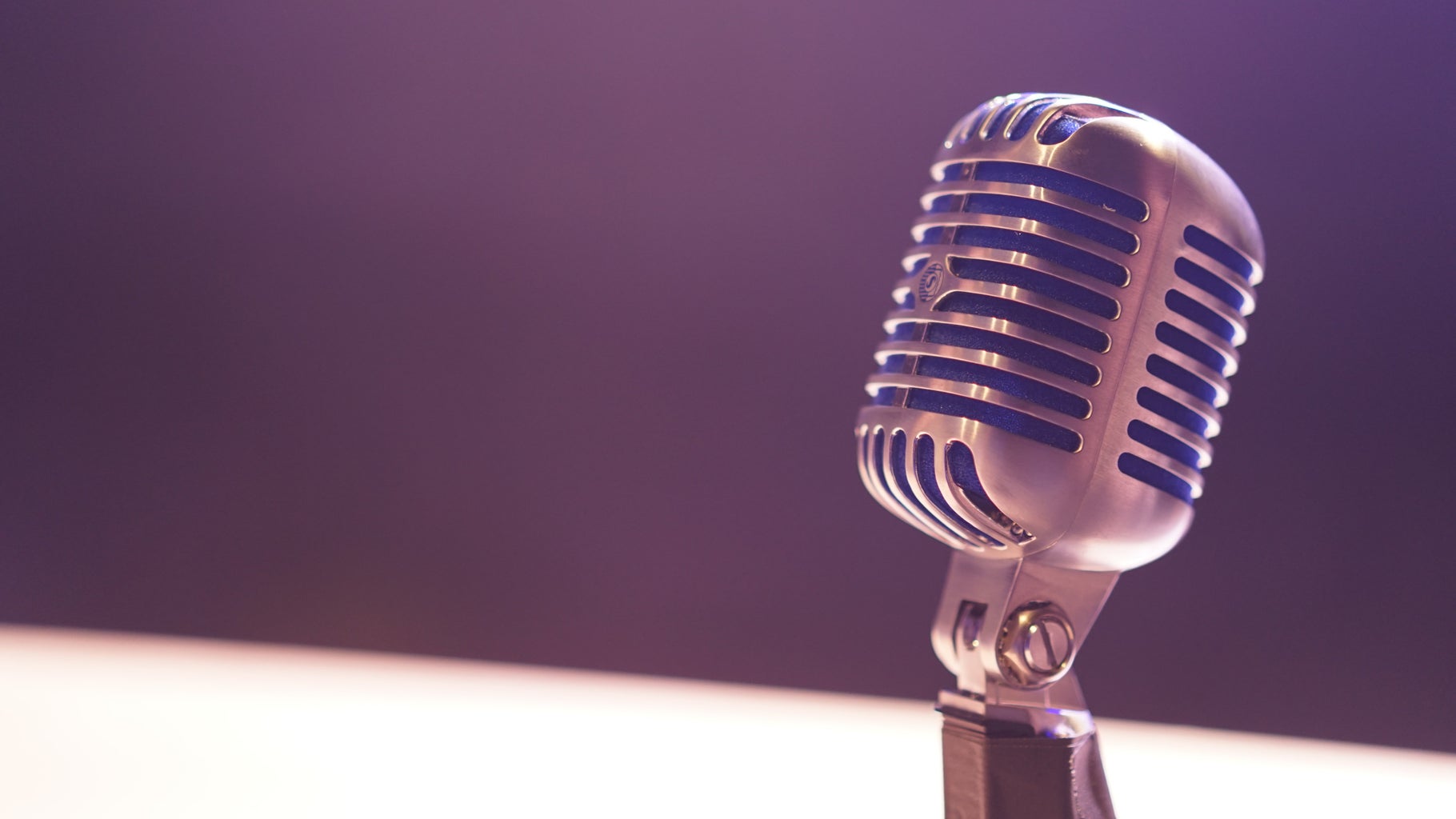 old fashioned crome microphone in front of a purple background