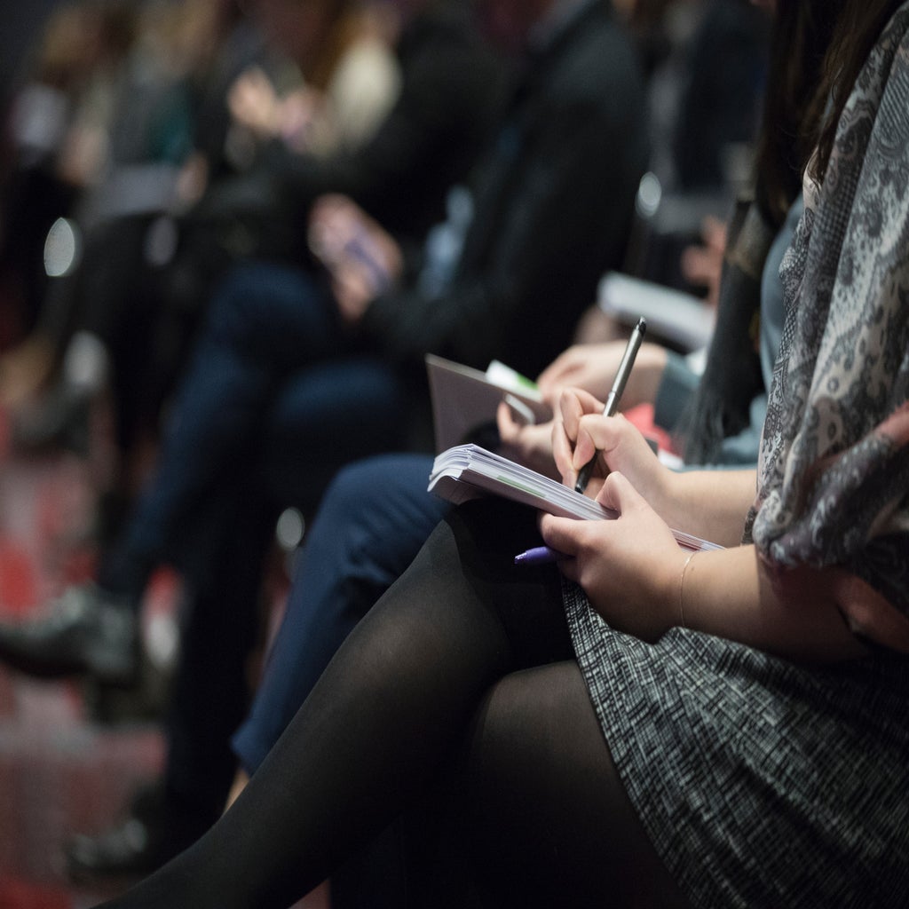 people sitting in chairs and taking notes