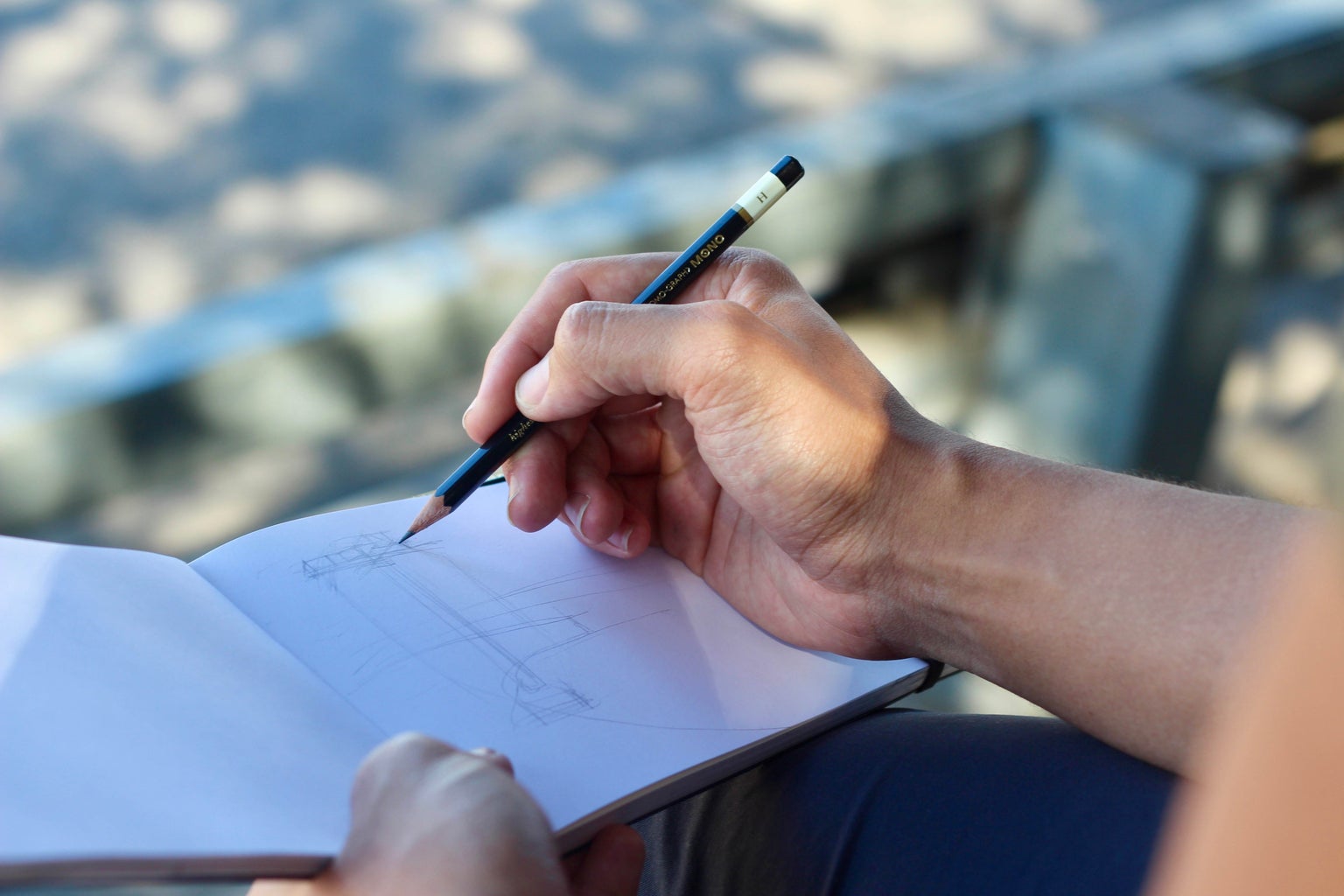 person sketching on a white pad