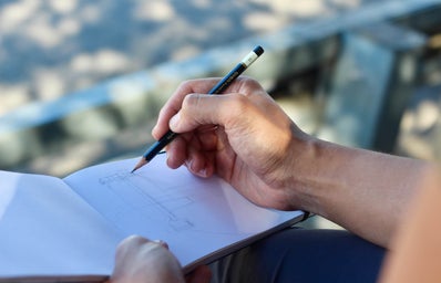 person sketching on a white pad