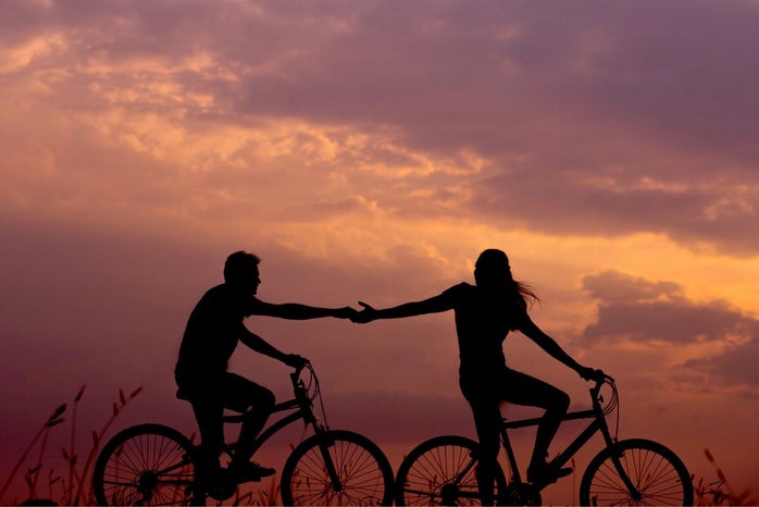 man and woman on bikes at sunset