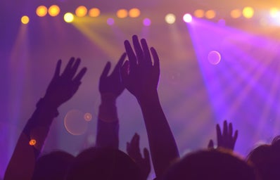 people with their hands raised during a concert