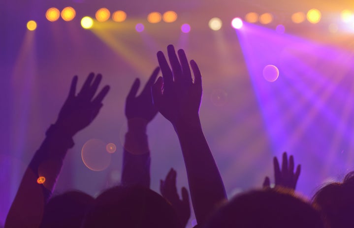 people with their hands raised during a concert