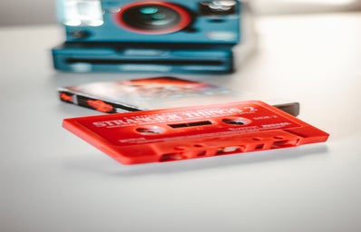 A red cassette sits on a table labeled \"stranger things\"