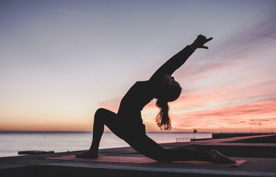 silhouette of woman doing yoga pose