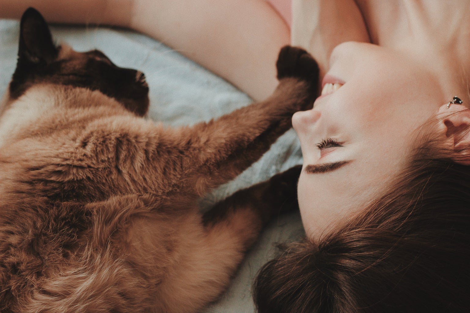 Girl lying on bed with cat