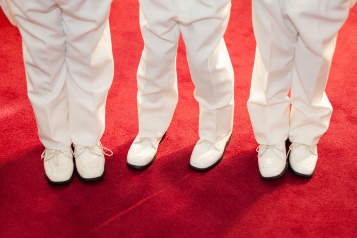 three boys standing on red carpet