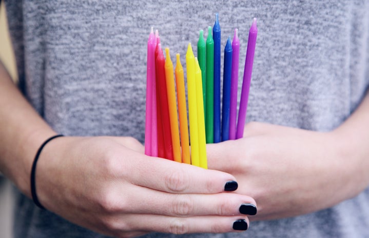 A person holding a collection of colorful birthday candles