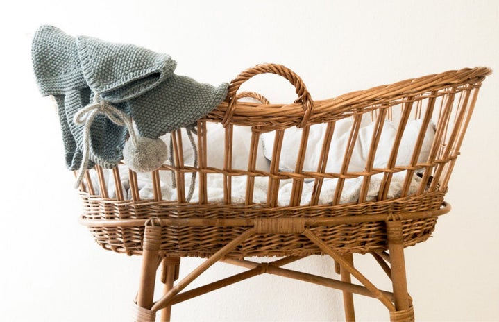 wicker baby basket with grey blanket