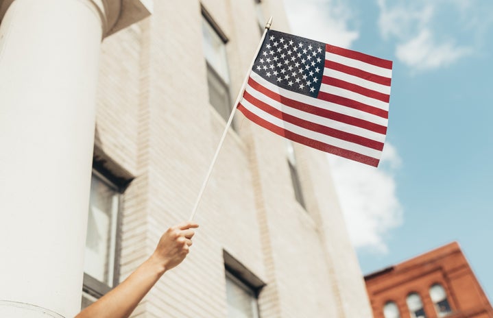 Waving a small flag in front of a building
