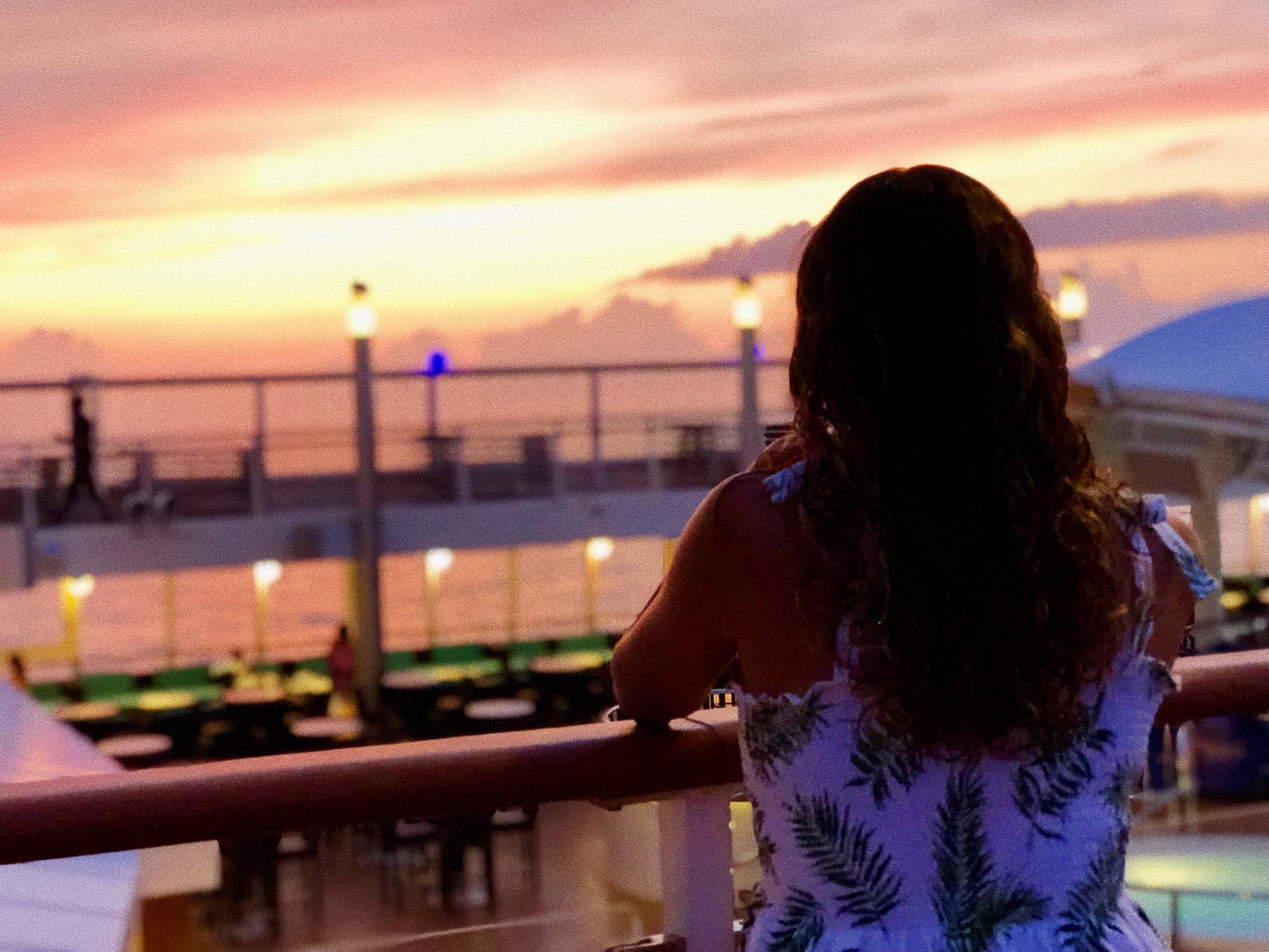 A woman is watching a sunset.