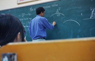 professor writing on a chalkboard