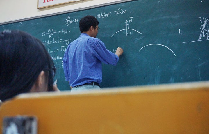 professor writing on a chalkboard