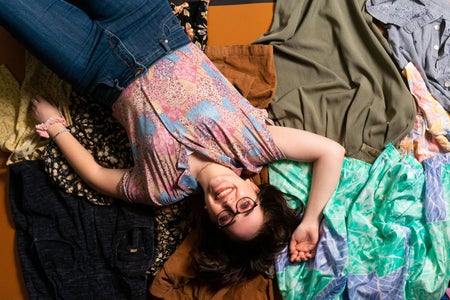 woman laying on pile of clothes