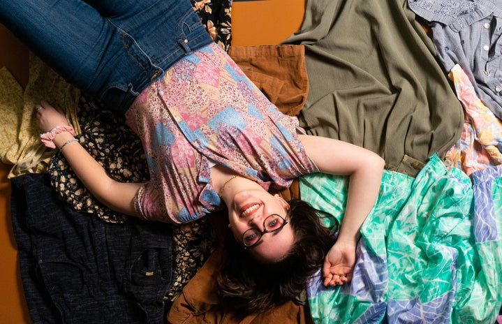 woman laying on pile of clothes