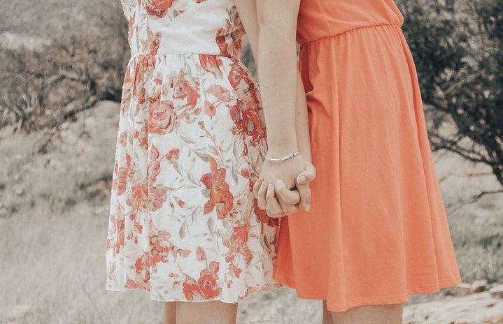 My sister and I taking pictures outside, holding hands.