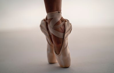 A ballerina on tip-toe in ballet slippers.