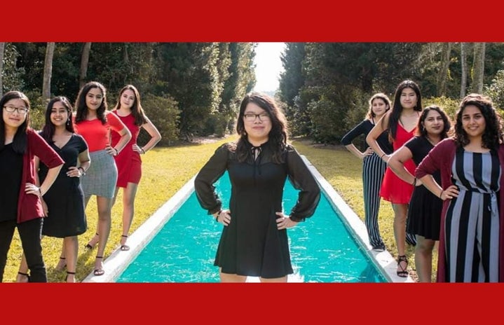 Jully standing in front of water with the rest of her executive board standing off to the sides of her