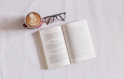 open book with a cup of coffee and glasses
