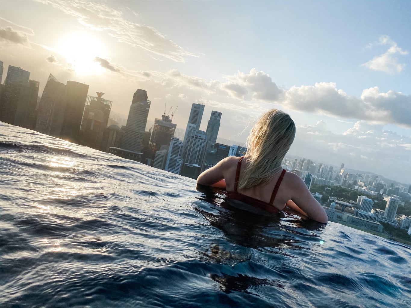 girl in pool with skyline of Singapore in background