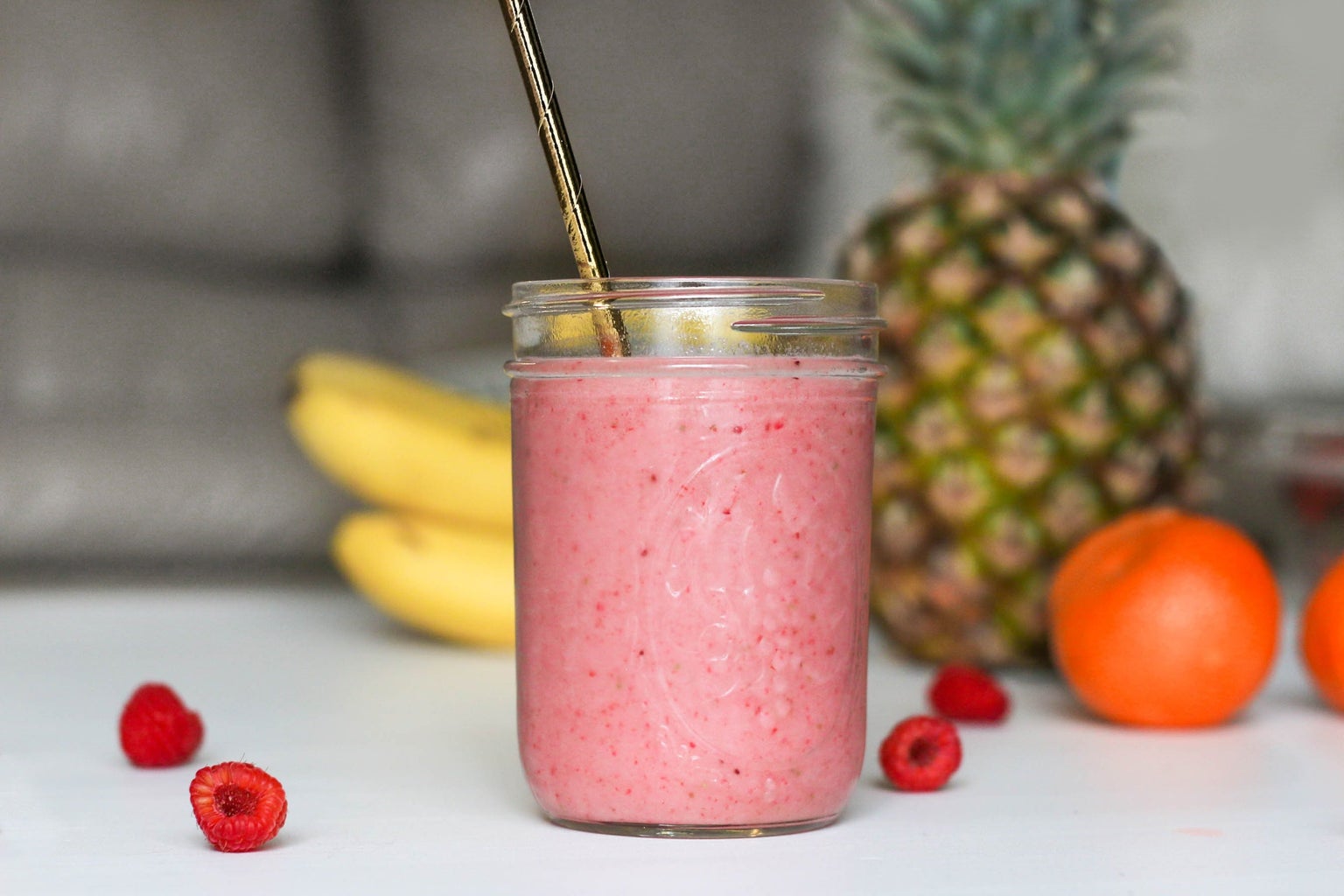 fruit smoothie in glass with metal straw