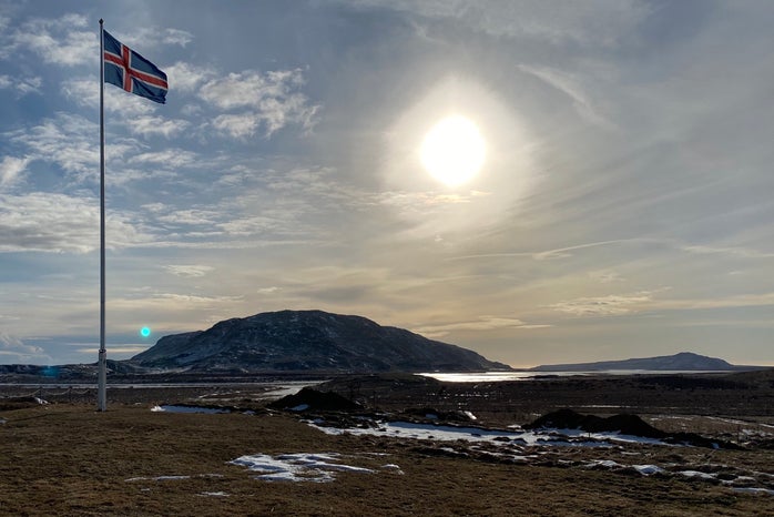 Icelandic flag with scenic background