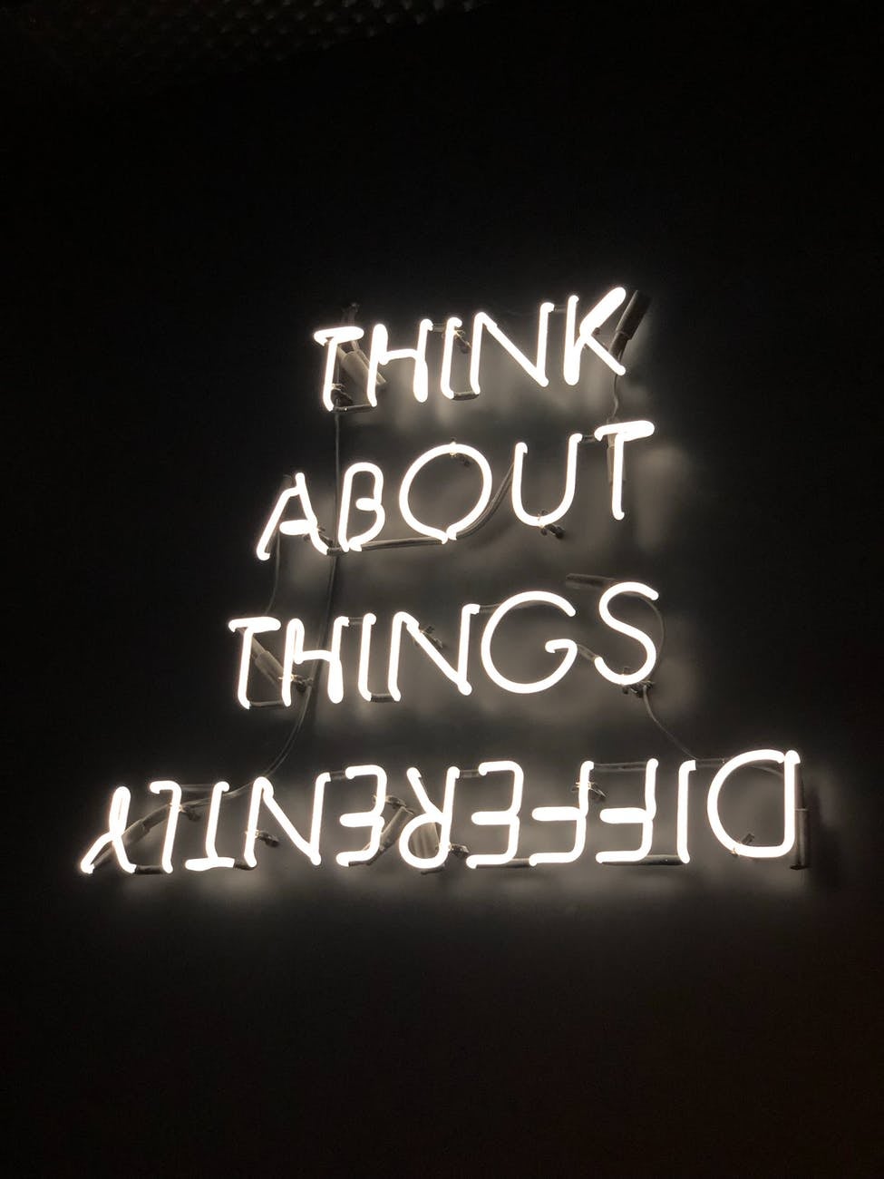 neon sign saying think about things differently