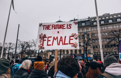 Crowd of women, one holding a sign that says \"the future is female\"