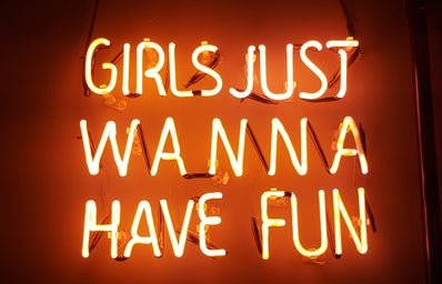 Neon lights that spell out "Girls Just Wanna Have Fun."