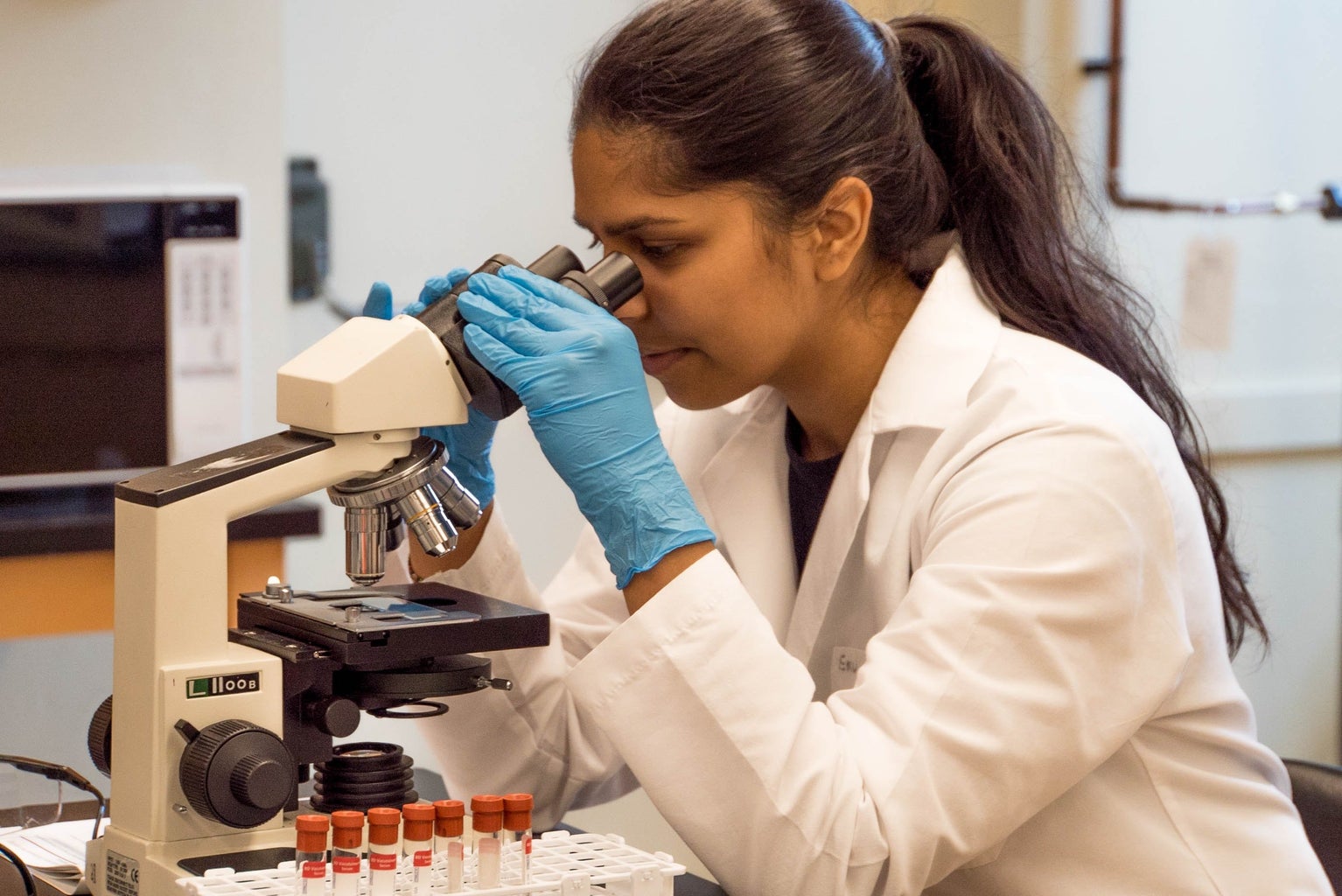 Woman looking into microscope