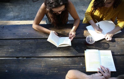 group of people reading and studying together at a table