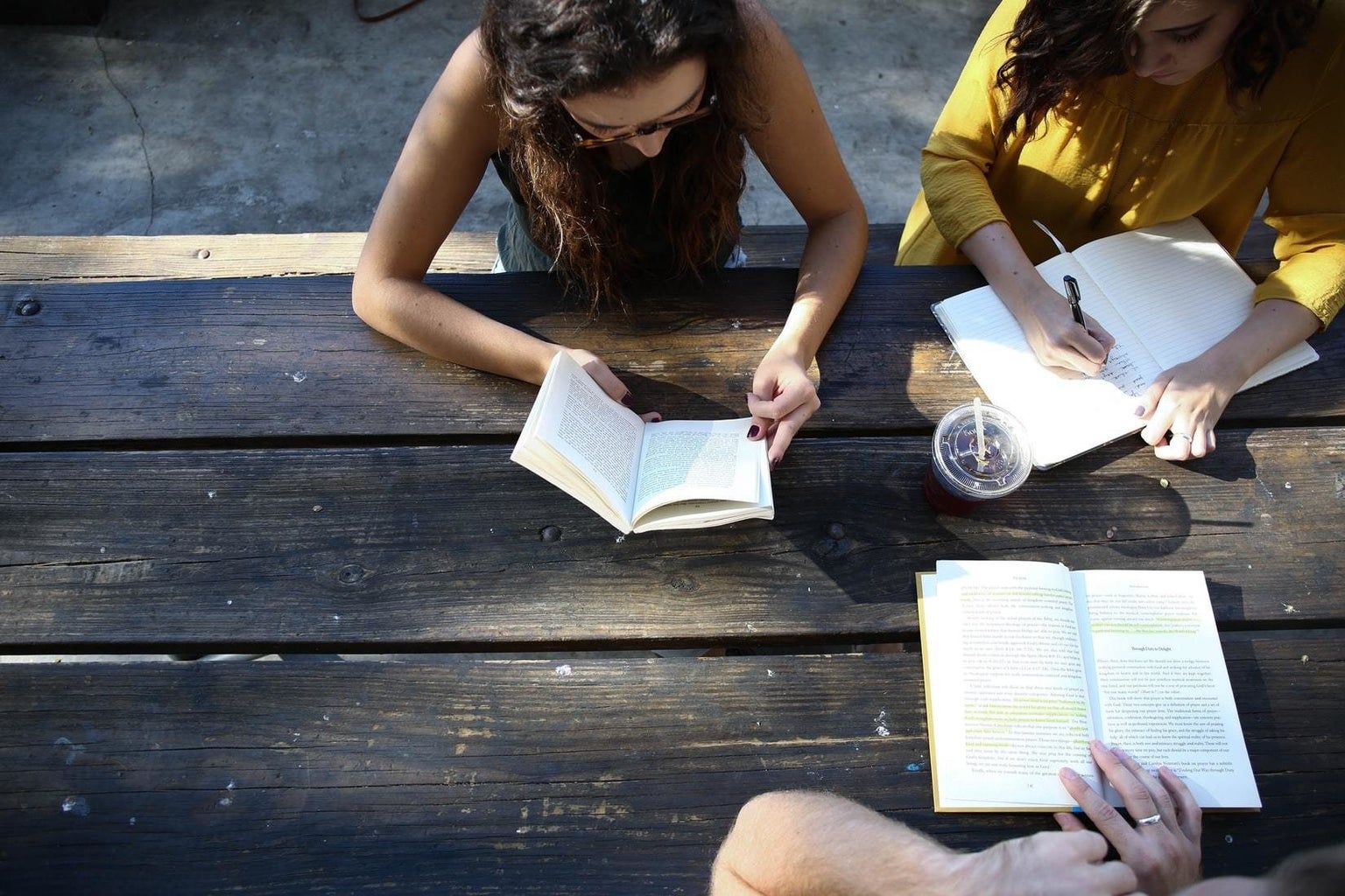 group of people reading and studying together at a table