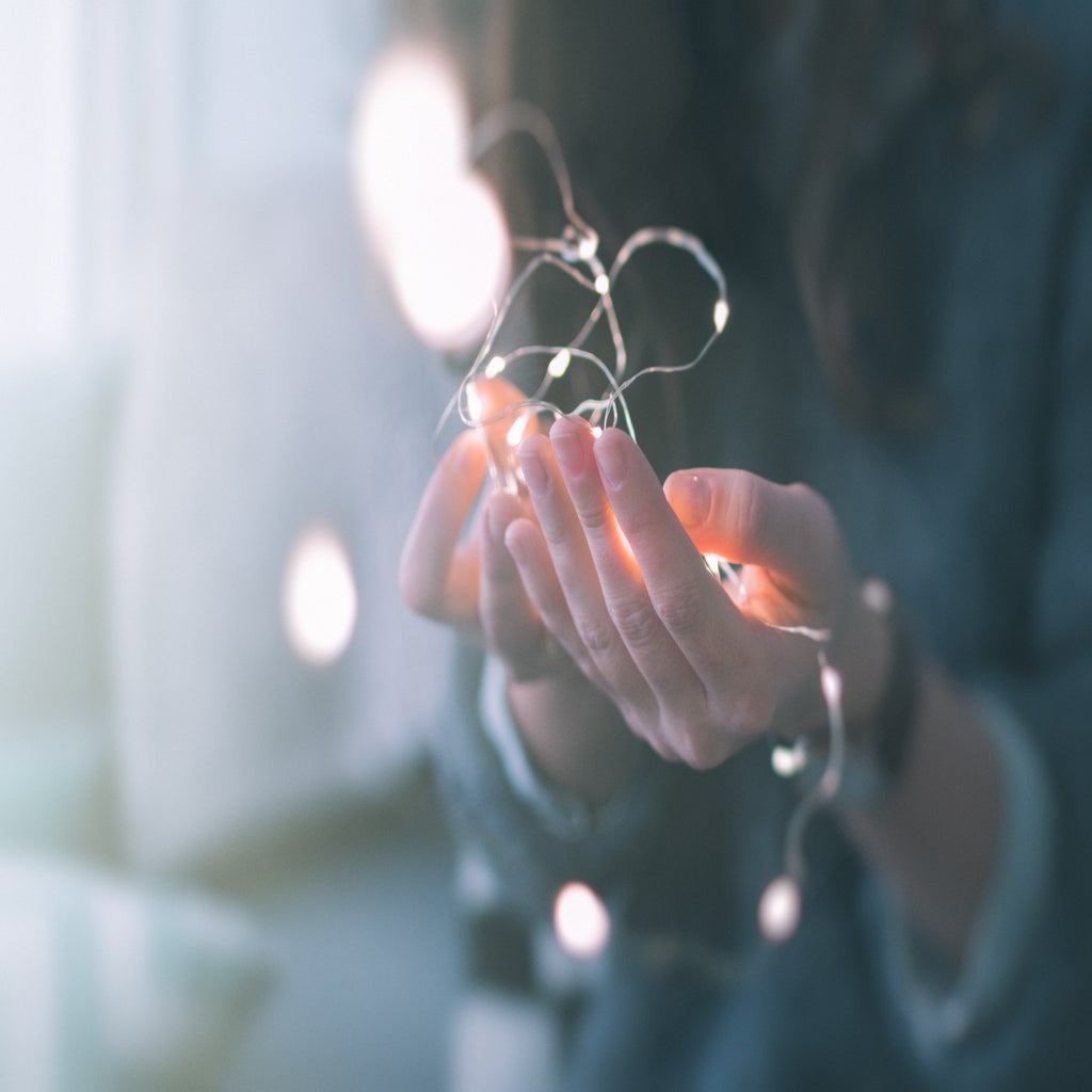 shallow focus of person holding string lights