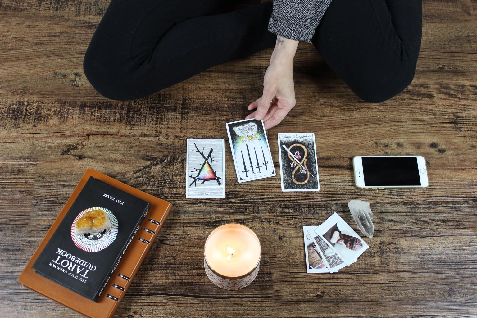 woman sitting on wooden floor with tarot card spread
