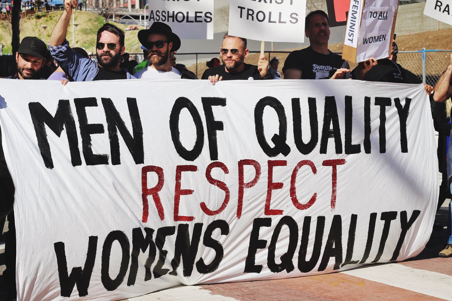 men holding up a banner for women's equality