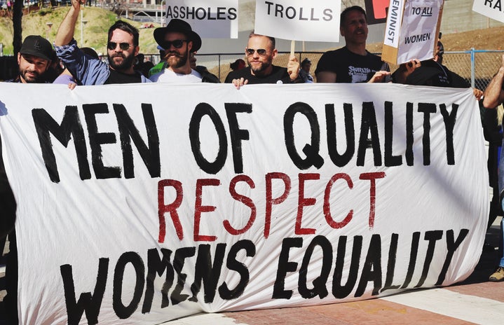 men holding up a banner for women's equality